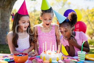 Portrait of cute girls preparing to blow on candle during a birt