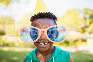Little boy wearing big toy glasses