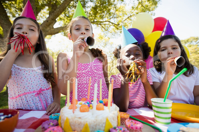 Children breathing out in a birthday trumpets during a birthday