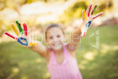 Little girl stretching out her painted hands