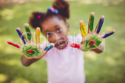 Little girl showing her painted hands to the camera