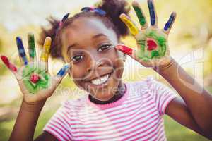 Little girl showing her painted hands to the camera