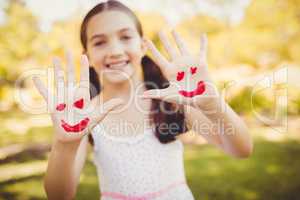 Little girl showing her painted hands to the camera
