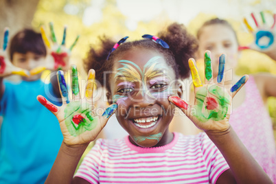 Portrait of a girl with make-up showing her painted hands