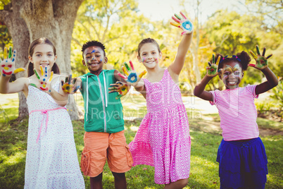 Portrait of cute children with make up having coloured hands