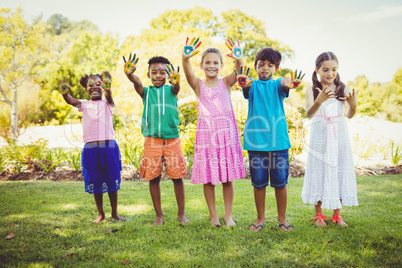 Portrait of cute children with make up having coloured hands