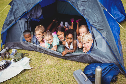 Smiling kids lying in the tent together