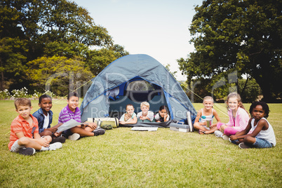 Smiling kids posing in the tent together during a sunny day