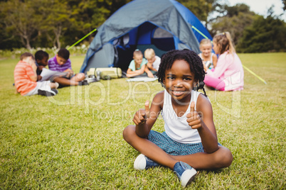 Happy child doing thumbs up during a sunny day