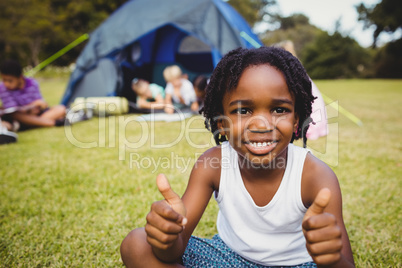 Happy child doing thumbs up during a sunny day