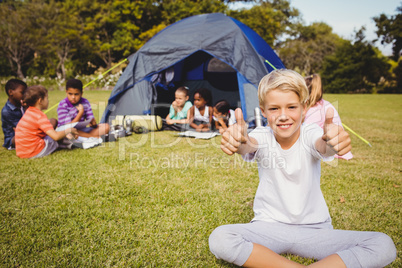 Happy child doing thumbs up during a sunny day