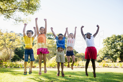 Happy kids jumping together during a sunny day