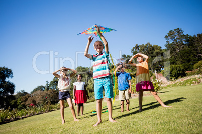 Kids playing together during a sunny day with a kite