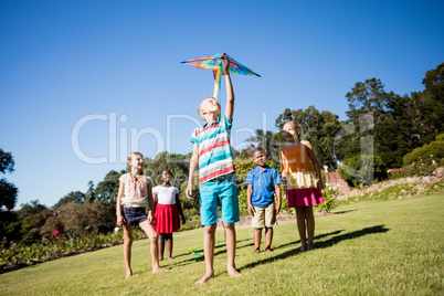 Kids playing together during a sunny day with a kite