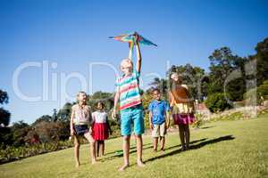 Kids playing together during a sunny day with a kite