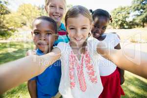 Kids taking a selfie together during a sunny day at camera