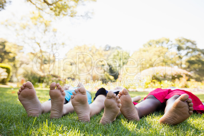 Kids are lying on the grass during a sunny day