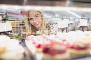 Portrait of woman looking at desserts shelf