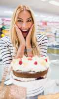 Happy woman with mouth open in front of cake