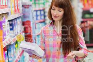 Woman with shopping basket holding product
