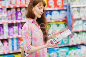 Profile view of woman with shopping basket holding product
