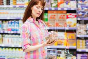 Concentrated woman choosing carefully a product