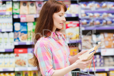 Concentrated woman choosing carefully a product