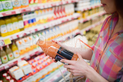 Close up view of woman choosing a bottle of fruits juice