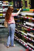 Casual woman taking bottle of wine