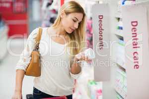 Casual woman picking a product and reading it