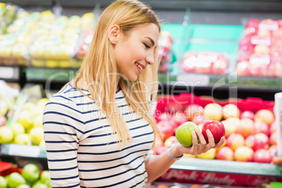 Customer at market holding fruits front of fruits shelf