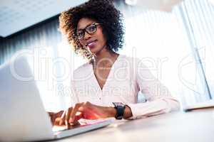 Businesswoman working on her computer and smiling