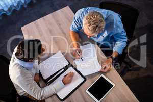 Two businessmen reading a document and interacting