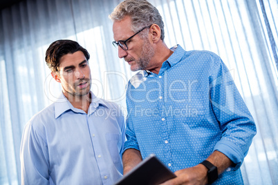 Two businessmen using a tablet computer