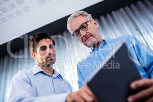 Two businessmen using a tablet computer