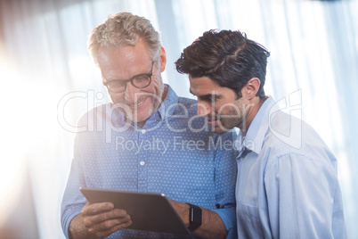 Two businessmen using a tablet computer