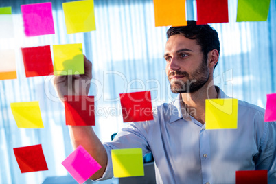 Businessman writing on post it