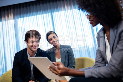 Business people having a discussion around a tablet computer