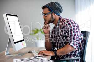 Serious casual man working at computer desk
