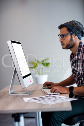 Side view of serious casual man working at computer desk