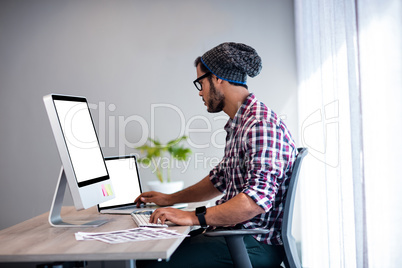 Serious hipster working at computer desk Serious hipster working at computer desk