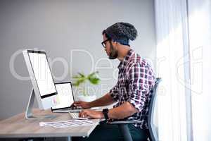 Serious hipster working at computer desk