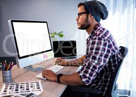 Serious hipster working at computer desk