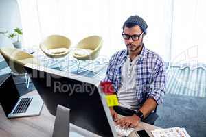 An hipster man working at computer desk