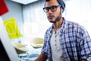 Focus on hipster man working at computer desk