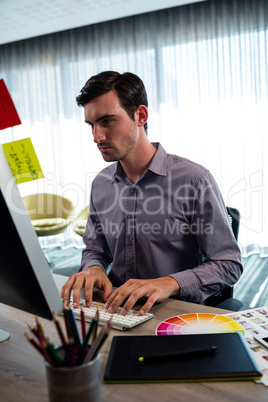 Portrait of serious casual man working at computer desk