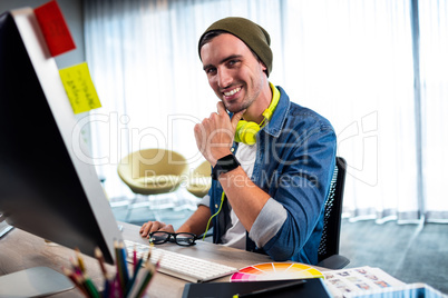 Portrait of smiling casual man working at computer desk