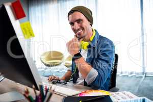 Portrait of smiling casual man working at computer desk