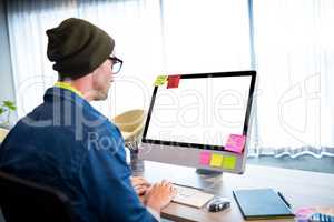 Side view of casual man working at computer desk