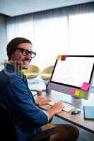 smiling casual man posing at computer desk